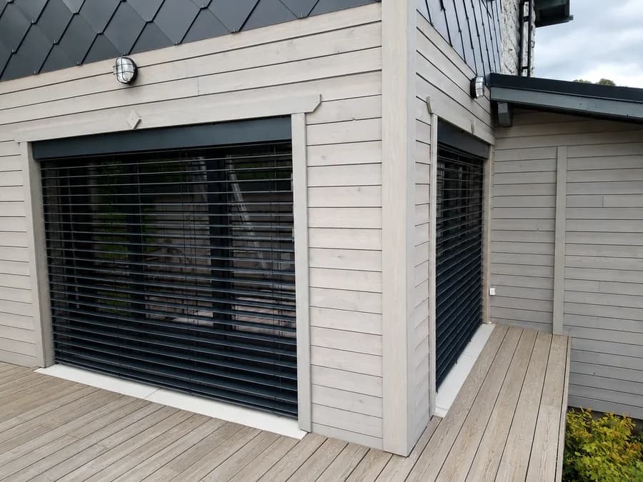 Brise-soleil orientable posé en tunnel sur une baie vitrée donnant sur une terrasse
